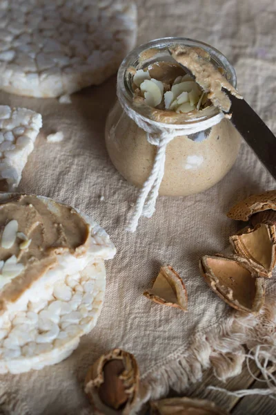 Mantequilla de almendras casera en una rebanada de pan crujiente de arroz . —  Fotos de Stock