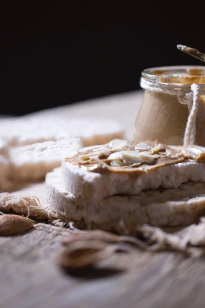 Burro di mandorle fatto in casa su una fetta di pane croccante di riso . — Foto Stock