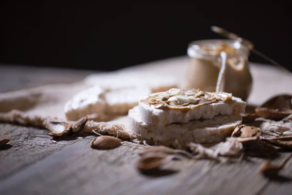 Burro di mandorle fatto in casa su una fetta di pane croccante di riso . — Foto Stock