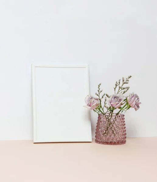 White frame with three pink roses on the desk
