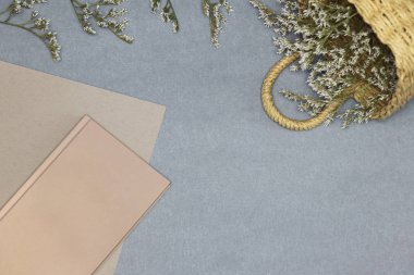 Pembe Notebook, kağıt ve mavi arka planda çiçekler ile saman sepeti