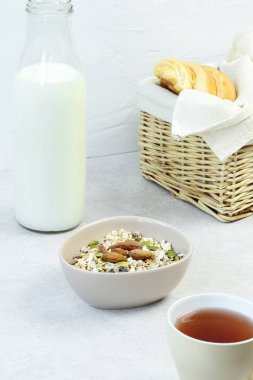 Gri masada süt, çay ve kruvasan ile Müsli kahvaltı