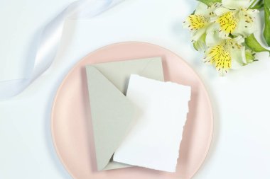 Pembe plaka üzerinde Mockup tebrik kartı, çiçek ve kurdele ile beyaz arka plan