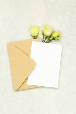 Zarf ve beyaz güller ile gri arka plan üzerinde Mockup davetiye kartı