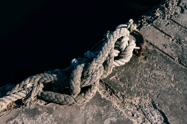 Marine knotted rope on pier close up.