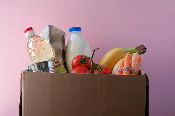 Karton mit Lebensmitteln. Tomaten, Bananen, Milch, Eier in Pappschachteln, Karotten, abgefülltes Öl. Online einkaufen. — Stockfoto