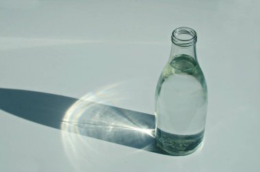 Beyaz arka planda klasik cam su şişesi.