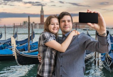 Genç çift selfie smartphone Venedik İtalya ile alıyor. Gondol arka planda.
