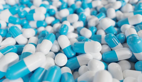 Muchas cápsulas azules y blancas en el fondo. Drogas y farmacia c — Foto de Stock