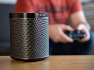 Uk, Ekim 2019: Sonolar arka planda oyuncu ile siyah kablosuz hoparlör oynuyorlar