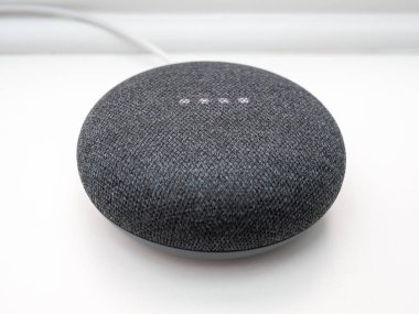 Beyaz arkaplanda akıllı ev bluetooth hoparlörünün yakın plan ışıklandırılması