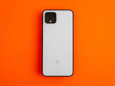 Uk, Ekim 2019: Turuncu arka planda Piksel 4 beyaz akıllı telefon