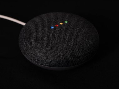 Uk, Ekim 2019: Google nest mini ürünü siyah arkaplanda ışıklandırıldı