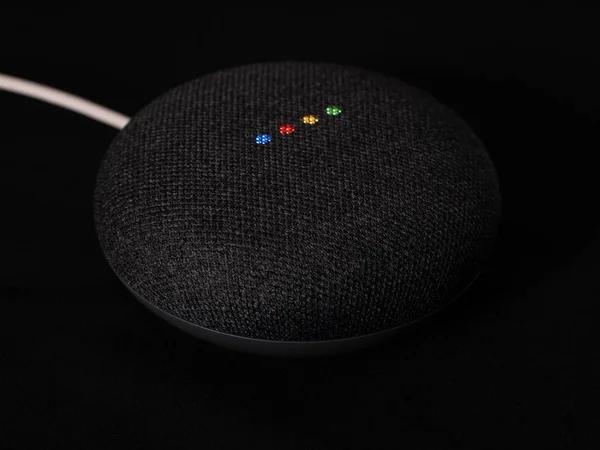 Uk, Ekim 2019: Google nest mini ürünü siyah arkaplanda ışıklandırıldı