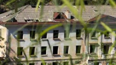 Bina, Sovyet sonrası zaman terk edilmiş. Kameranın odak dışında spikelets vardır ön planda konut dışı bir bina boyunca hareket eder. Yaz güneşli gün.