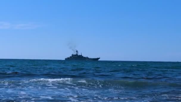 沿着海岸航行的军舰 军用巡洋舰在地平线上 平均计划 在晴朗的天空背景下 船在海面上缓慢航行 — 图库视频影像