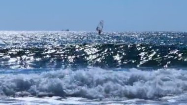 Akşam deniz kalan, dalgalar üzerinde kurulu yelken. Yaz akşam deniz kenarı.