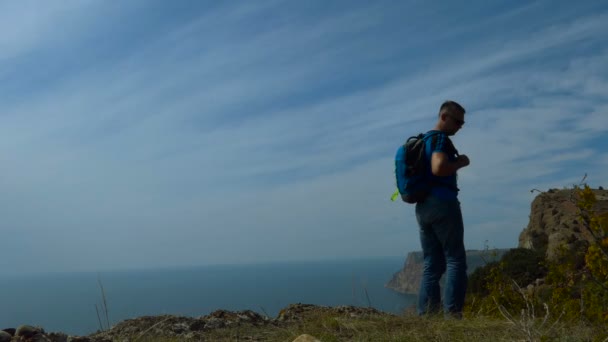 Man Backpack Turns Leaves Top Mountain Landscape Sea Mountains Cloudy — Stock Video
