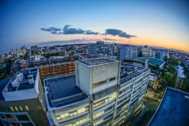 Gün batımına sarılmış Chofu şehrinin çatıları.