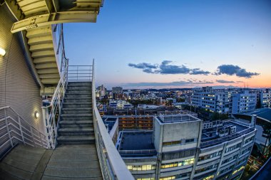 Gün batımına sarılmış Chofu şehrinin çatıları.
