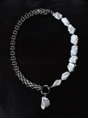 Siyah deri arka planda gösterişli, zarif, barok inci kolye. Yakın çekim. 