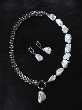 Siyah deri arka planda bir dizi barok inci. Yakın çekim. 