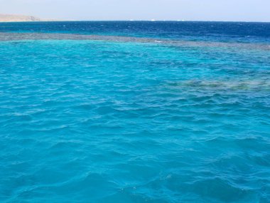 Deniz yüzeyinde parlak mavi dalgalar