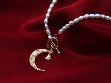 Kırmızı ipek desenli, kadife kumaşlı inci kolyeli altın hilal ay kolyesi.