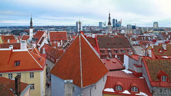 Winter view on snow covered roof tiles of Tallinn city buildings