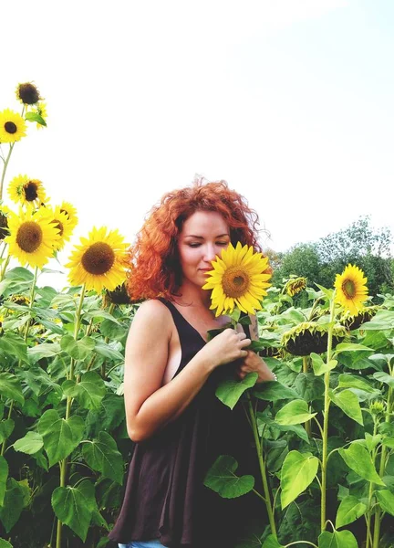 快乐的红头发的女孩在向日葵的领域享受夏天 — 图库照片