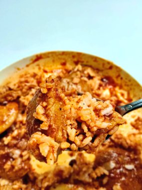 Semur Jengkol 'un yakın çekimi, Endonezya' dan geleneksel bir Sundan yemeği. Bir kaşık dolusu kaldırılır, zengin, baharatlı sosu ve haşlanmış jengkol 'u gösterir..