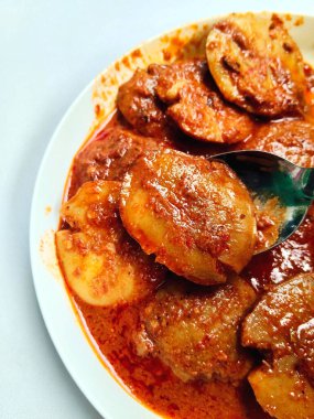 Semur Jengkol 'un yakın çekimi, Endonezya' dan geleneksel bir Sundan yemeği. Bir kaşık dolusu kaldırılır, zengin, baharatlı sosu ve haşlanmış jengkol 'u gösterir..