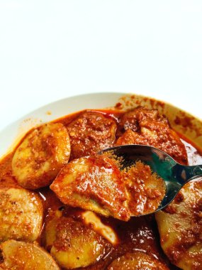 Semur Jengkol 'un yakın çekimi, Endonezya' dan geleneksel bir Sundan yemeği. Bir kaşık dolusu kaldırılır, zengin, baharatlı sosu ve haşlanmış jengkol 'u gösterir..