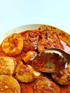 Semur Jengkol 'un yakın çekimi, Endonezya' dan geleneksel bir Sundan yemeği. Bir kaşık dolusu kaldırılır, zengin, baharatlı sosu ve haşlanmış jengkol 'u gösterir..