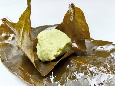 Bir porsiyon bant ketan, geleneksel bir Endonezya tatlı mayalanmış pirinç, beyaz arka planda sarılı porsiyonlar.