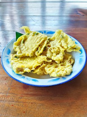 Bir tabak geleneksel Endonezya Tempe Mendoan, lezzetli bir kızarmış tempeh, kırsal bir tabakta servis edilir..