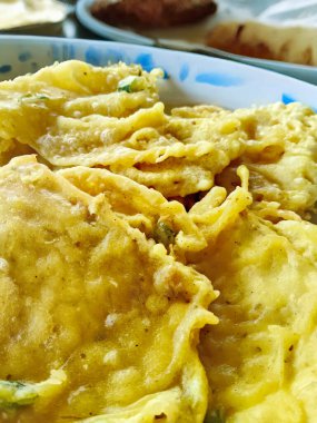 Bir tabak geleneksel Endonezya Tempe Mendoan, lezzetli bir kızarmış tempeh, kırsal bir tabakta servis edilir..