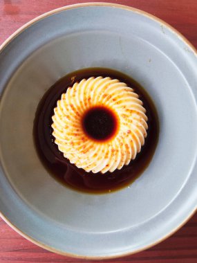 Zarif ve lezzetli bir Japon sütlü pudingi, modern bir tatlı, tatlı ve lezzetli soya soslu seramik bir kasede servis edilir..