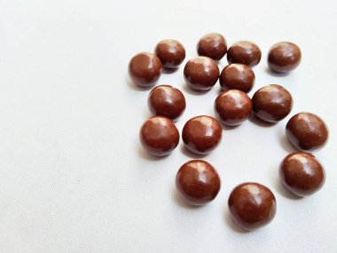 A pile of delicious, round, chocolate-coated biscuit balls on a clean white background, perfect for a sweet and satisfying snack.
