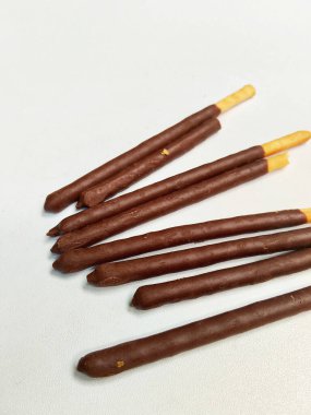 Temiz beyaz arka planda lezzetli bir çikolata kaplamalı çıtır bisküvi yığınının yakın plan çekimi..