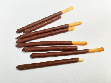 Temiz beyaz arka planda lezzetli bir çikolata kaplamalı çıtır bisküvi yığınının yakın plan çekimi..