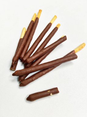 Temiz beyaz arka planda lezzetli bir çikolata kaplamalı çıtır bisküvi yığınının yakın plan çekimi..