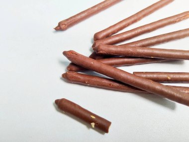 Temiz beyaz arka planda lezzetli bir çikolata kaplamalı çıtır bisküvi yığınının yakın plan çekimi..