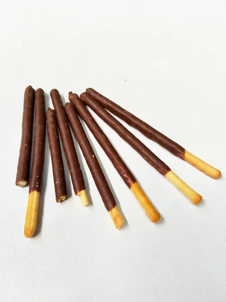 Temiz beyaz arka planda lezzetli bir çikolata kaplamalı çıtır bisküvi yığınının yakın plan çekimi..