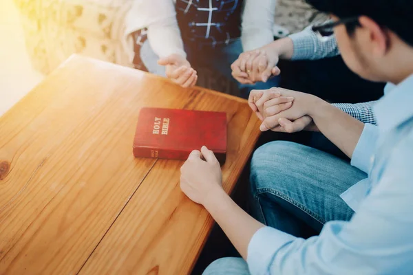 基督教小团体牵着手 在木制桌子周围祈祷 圣经上有圣经上关于返校 礼拜或祈祷会的概念 — 图库照片