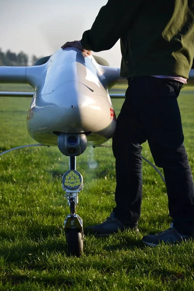 男子准备无人驾驶飞机的轻型和摄像头起飞地面上 绿色草地机场 晴朗的夏日早晨 — 图库照片