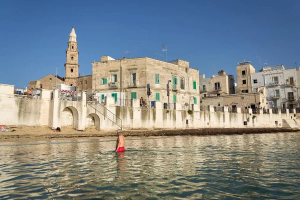 レッチェ イタリア 2018 2018 日イタリアのレッチェでの日の出の間にポルタ ヴェッキア大聖堂の近くのビーチで泳ぐを人々 します — ストック写真