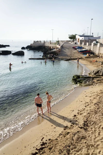 Monopoli, İtalya - 2 Temmuz 2018: Porta Vecchia Cathedral yakınındaki plajda yüzme sırasında 2 Temmuz 2018 Monopoli, İtalya için sunrise insanlar.