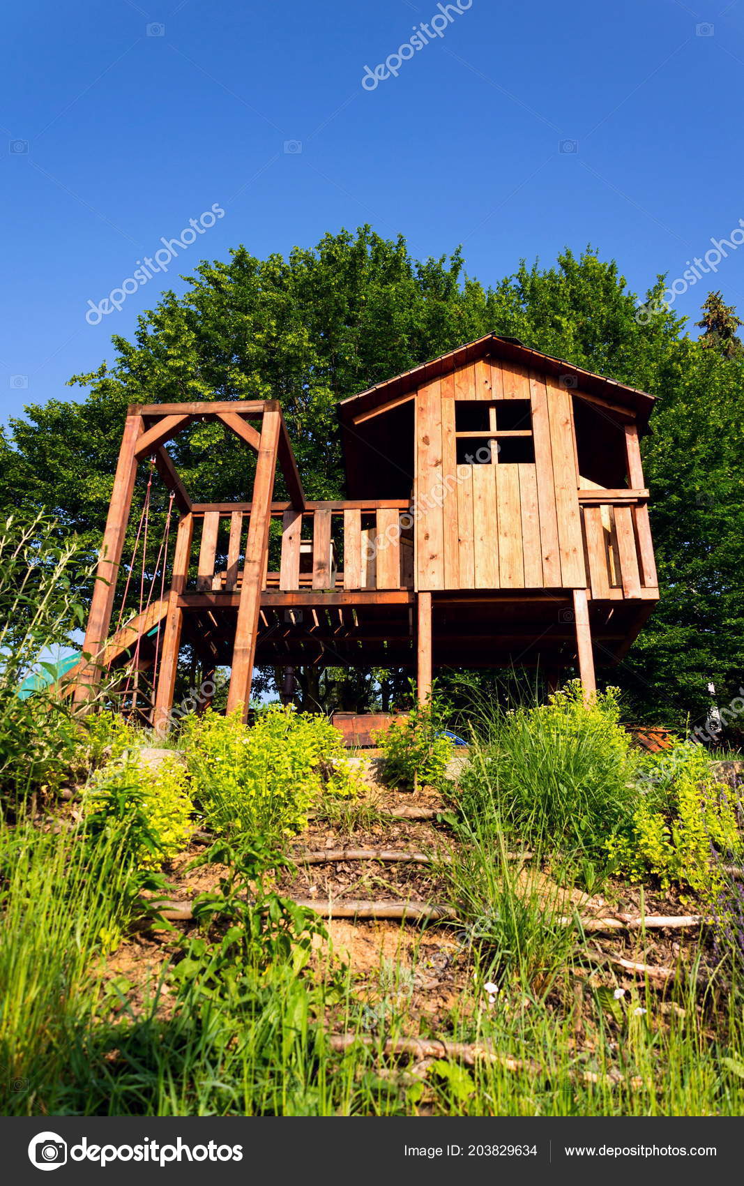 wooden playhouse with slide and swing
