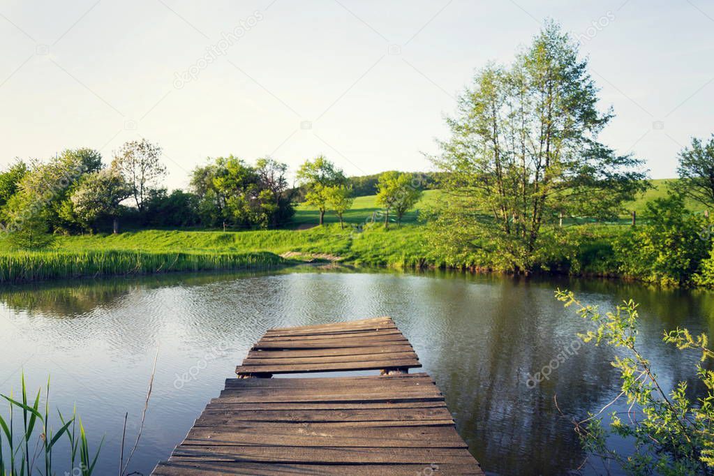 Pretty wooden pier at pond during sunset, colorful summer day, new life change concept, fresh start, new year resolution, dieting and healthy lifestyle